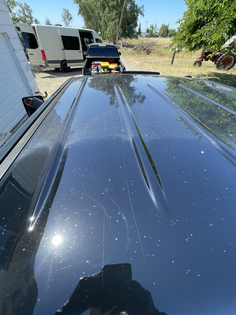 Black truck paint before polish with visible surface marks